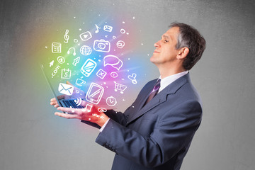 Businessman holding notebook with colorful hand drawn multimedia