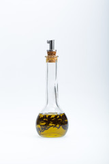 Thyme infused olive oil over white background
