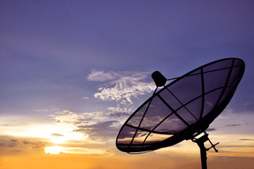 A satellite dish on twilight sky background