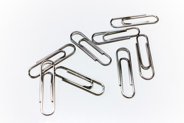 Scattered Silver Paper Clips on a Clean White Background