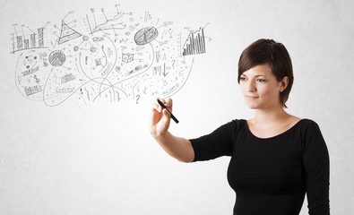 Pretty girl sketching graphs and diagrams on wall