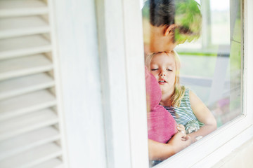 Mother and daughter looking through the window