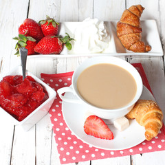 breakfast with croissants, strawberry  and cup of coffe on white