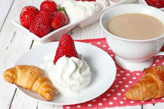 breakfast with croissants, strawberry  and cup of coffe on white