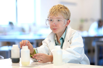 School boy making experiments in the chemical laboratory 