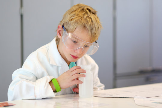 School boy making experiments in the chemical laboratory 