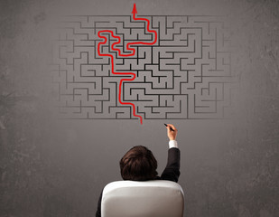 Business man looking at a maze and the way out