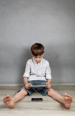 Fototapeta premium Boy playing on tablet
