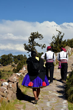 Hombres y mujer de la isla de Taquile con traje de fiesta . Perú