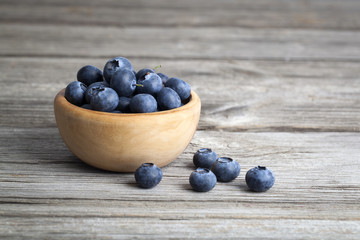 bowl of blueberries on wooden background