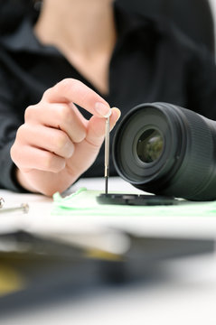 woman engineer repairing camera lens