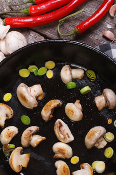 fried mushrooms with leeks in the pan vertical