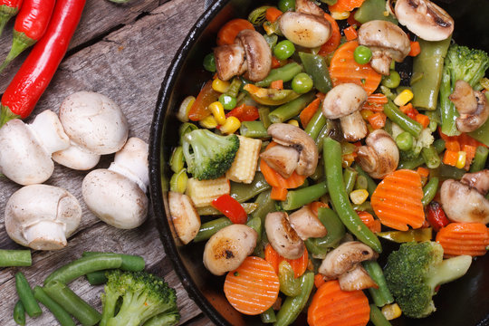 fried mushrooms with vegetables in a pan top view