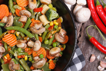 fried mushrooms with vegetables in a pan macro.
