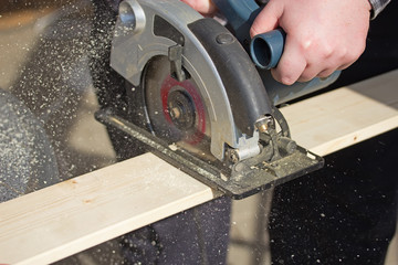 Man is working with electric circular saw