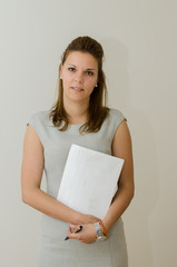 Young business woman standing with documents
