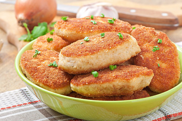 Chicken cutlets in a green bowl