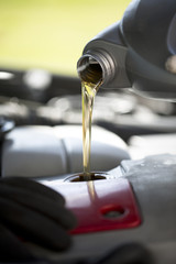 Fresh oil pouring into a car engine during a service