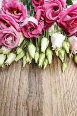 Bouquet of pink eustoma flowers on wooden table