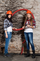 Two young long-haired woman with cables