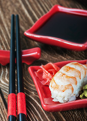 seafood sushi and chopsticks on a red plate