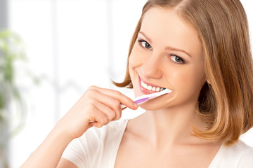 happy woman brushing her teeth with a toothbrush