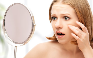 beautiful healthy woman  frightened saw in the mirror acne and w