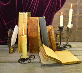 Open diary with old books and candles