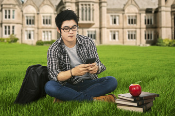 Male student using mobilephone outdoor