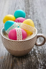 Obraz na płótnie Canvas Colorful Easter eggs in a decorative cup