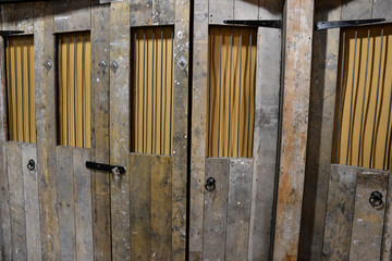 Old wooden door with metal bars in natural light