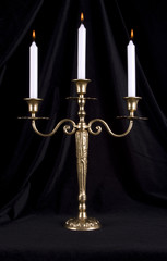 Vintage brass candelabrum with three burning candles