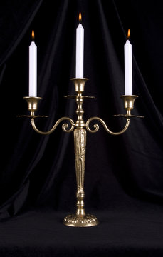 Vintage brass candelabrum with three burning candles