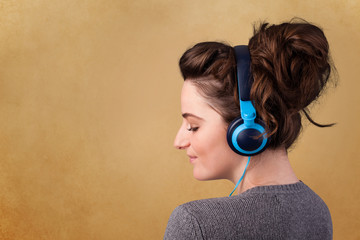 Young woman with headphones listening to music with copy space