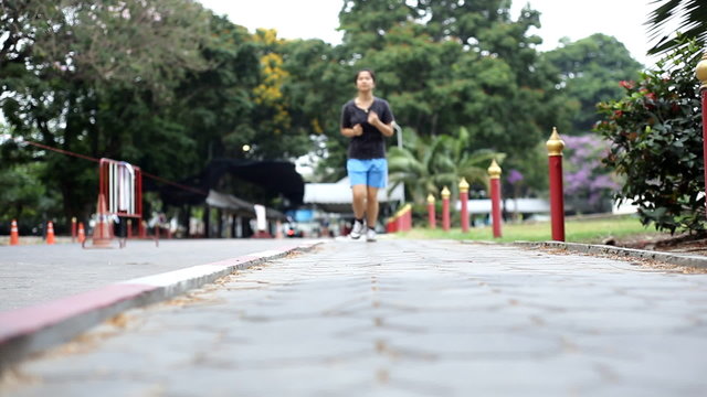 Female jogger. Young Asian woman jogging in park, Slide camera