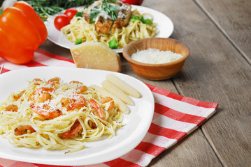 Pasta with shrimps and sauce on the wooden table