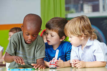 Kinder spielen im Kindergarten mit Bausteinen - obrazy, fototapety, plakaty