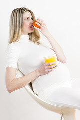 portrait of pregnant woman with a glass of orange juice and an o