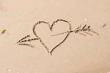 heart with an arrow written on the sand