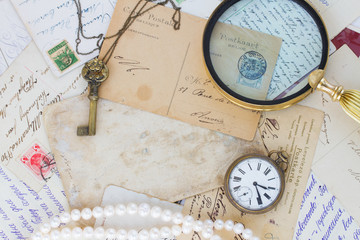 old mail  with  old clock, key and loupe