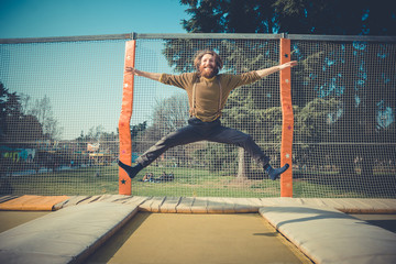 man jumping on trampoline at playground