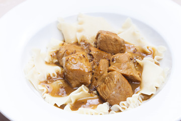 pork pieces on cumin with pasta
