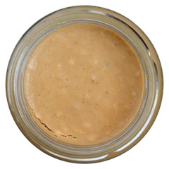 Glass jar of crunchy peanut butter shot from above.