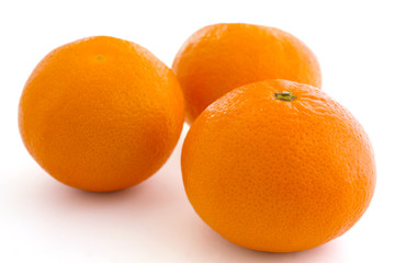 Three mandarins on white surface