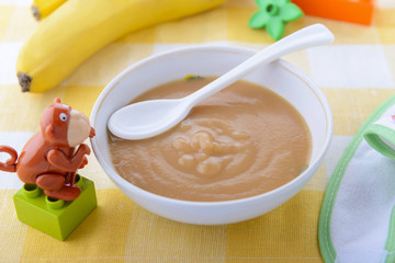 Puree from banana in child`s plate