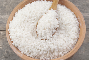 Obraz na płótnie Canvas biały ryż w misce na drewnianym stole