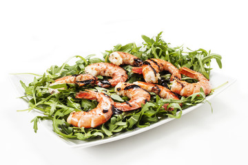 Gamberi con rucola su sfondo bianco