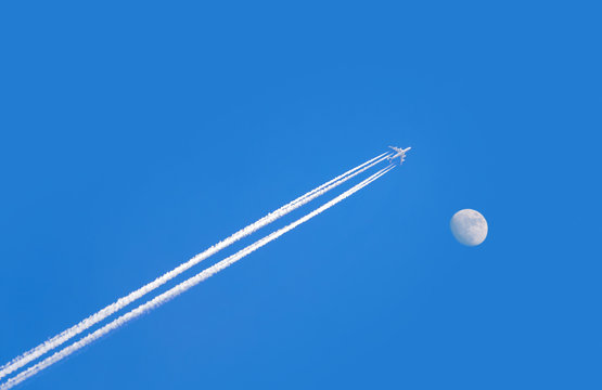 jet airplane on blue sky with moon - Powered by Adobe