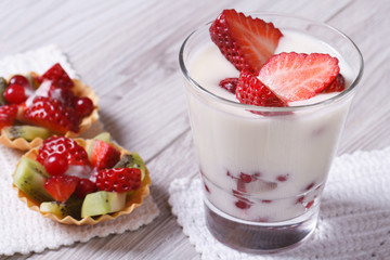 yogurt with fresh strawberries and fruit tartlets closeup