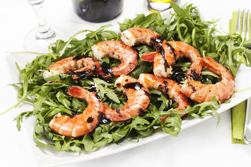 Gamberoni con rucola su sfondo bianco